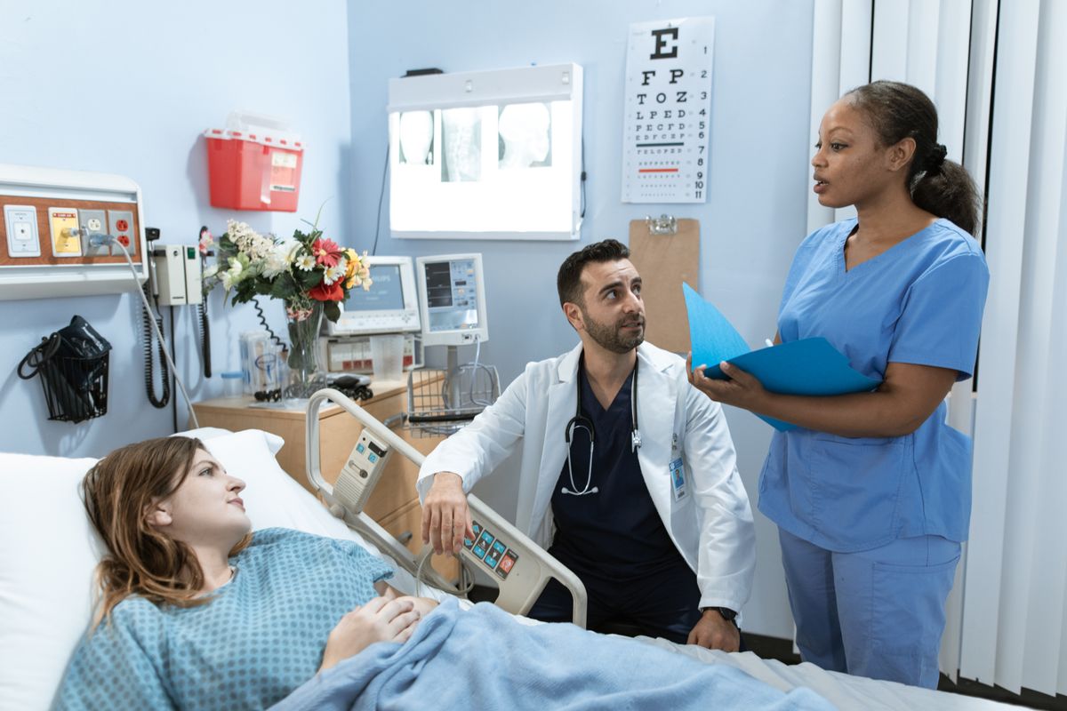 A healthcare professional speaking with a patient in a bright room